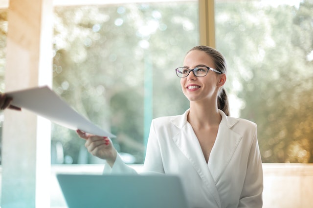 Smiling-person-being-handed-a-stack-of-papers